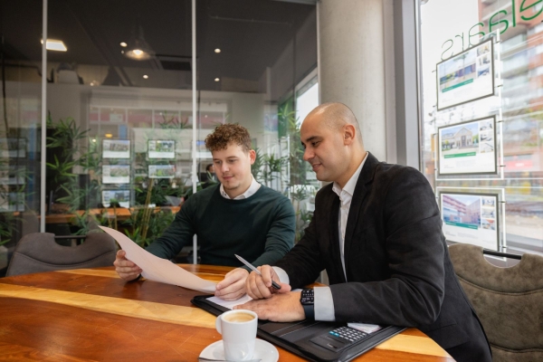 Twee mannen bespreken documenten in kantoor.