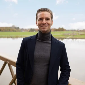 Man poseert buiten voor een landelijke achtergrond.