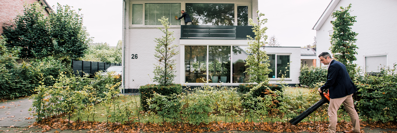 Man met bladblazer voor huis