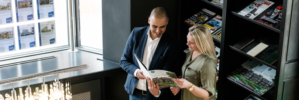 Twee mensen bekijken brochure in kantoor.