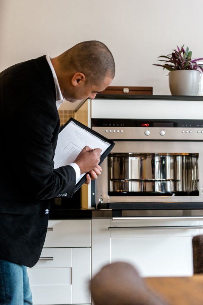Inspectie keukenapparaat door man met notitieblok