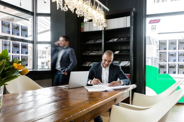 Kantoorruimte met man achter bureau, lachend