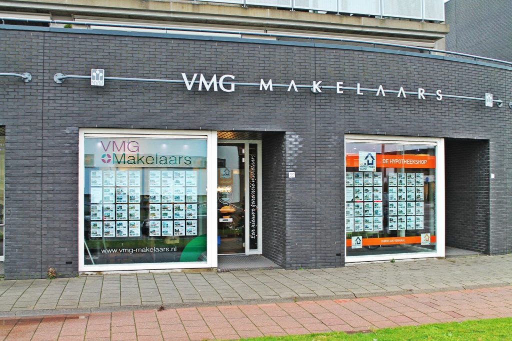 Gevel van makelaarskantoor in Nederland met etalages.