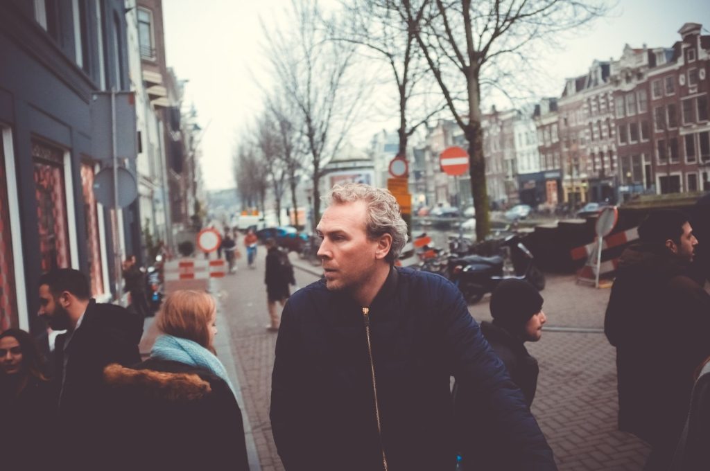 Man loopt op Amsterdamse straat in winter.