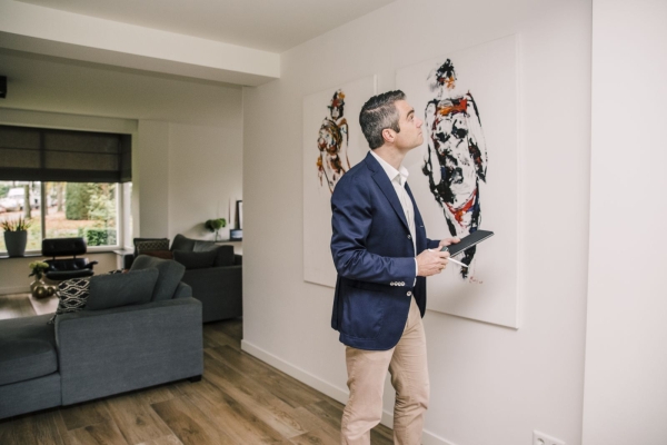 Man bekijkt kunst in woonkamer met tablet.