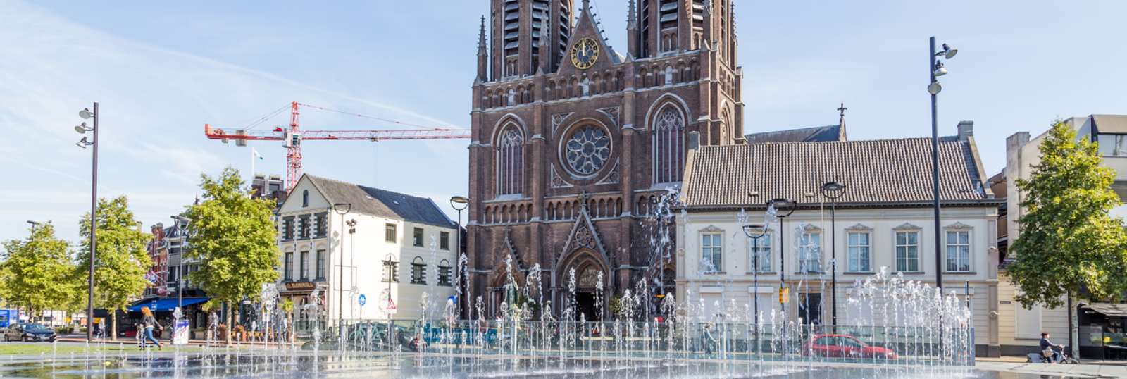 Kerk met fontein op plein, zonnige dag.