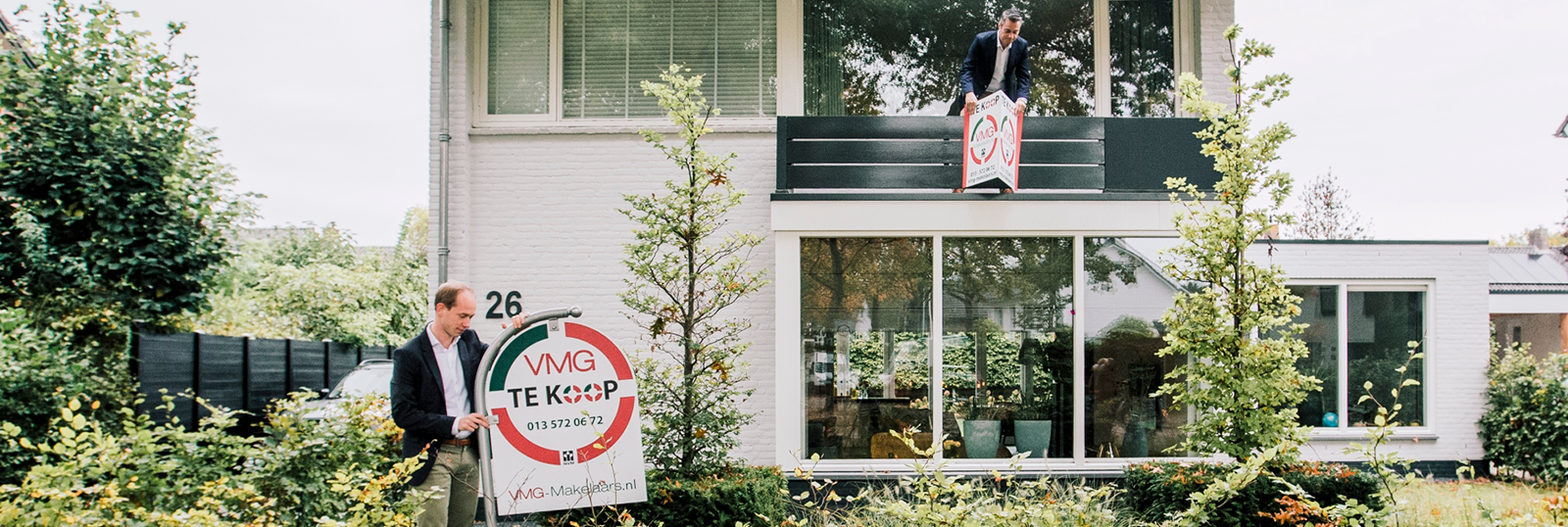 Huis te koop met makelaarsbord in tuin