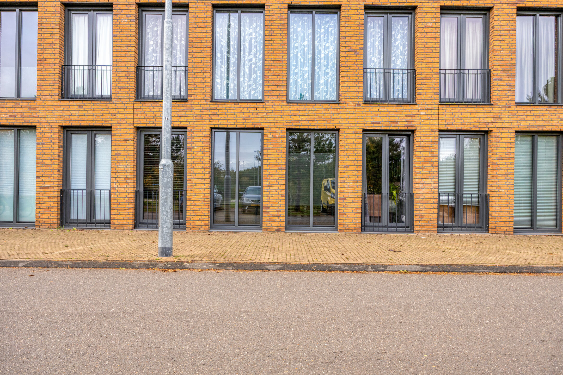 Appartementencomplex met bakstenen gevel en lantaarnpaal